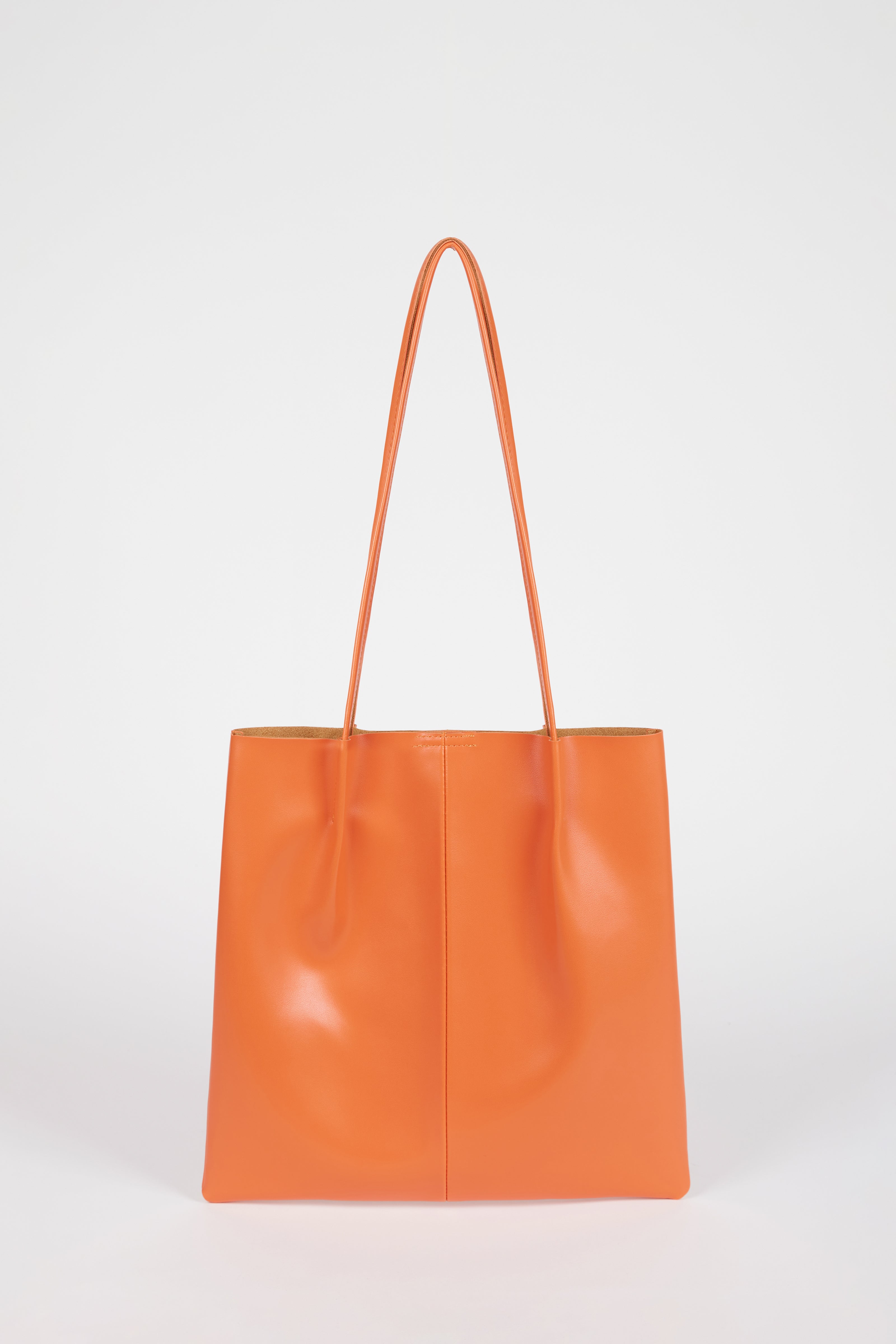 Orange vegan leather pinched strap tote bag